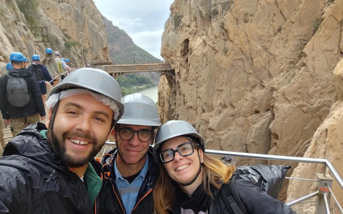A family photographing the gorge from the Caminito del Rey walkway