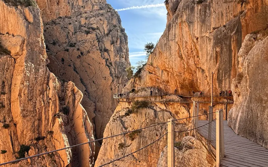 The wooden boardwalk of the Caminito del Rey clinging to the rock face