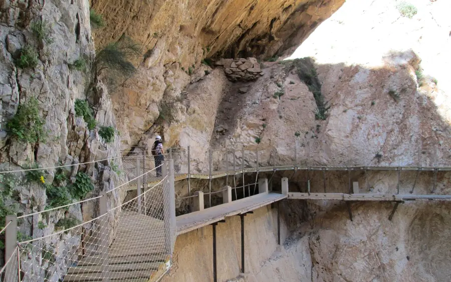 A group in helmets walking the Caminito del Rey boardwalk