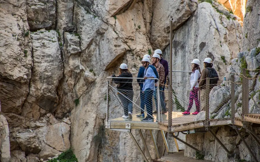 Walkers on the Caminito del Rey with the gorge falling away below